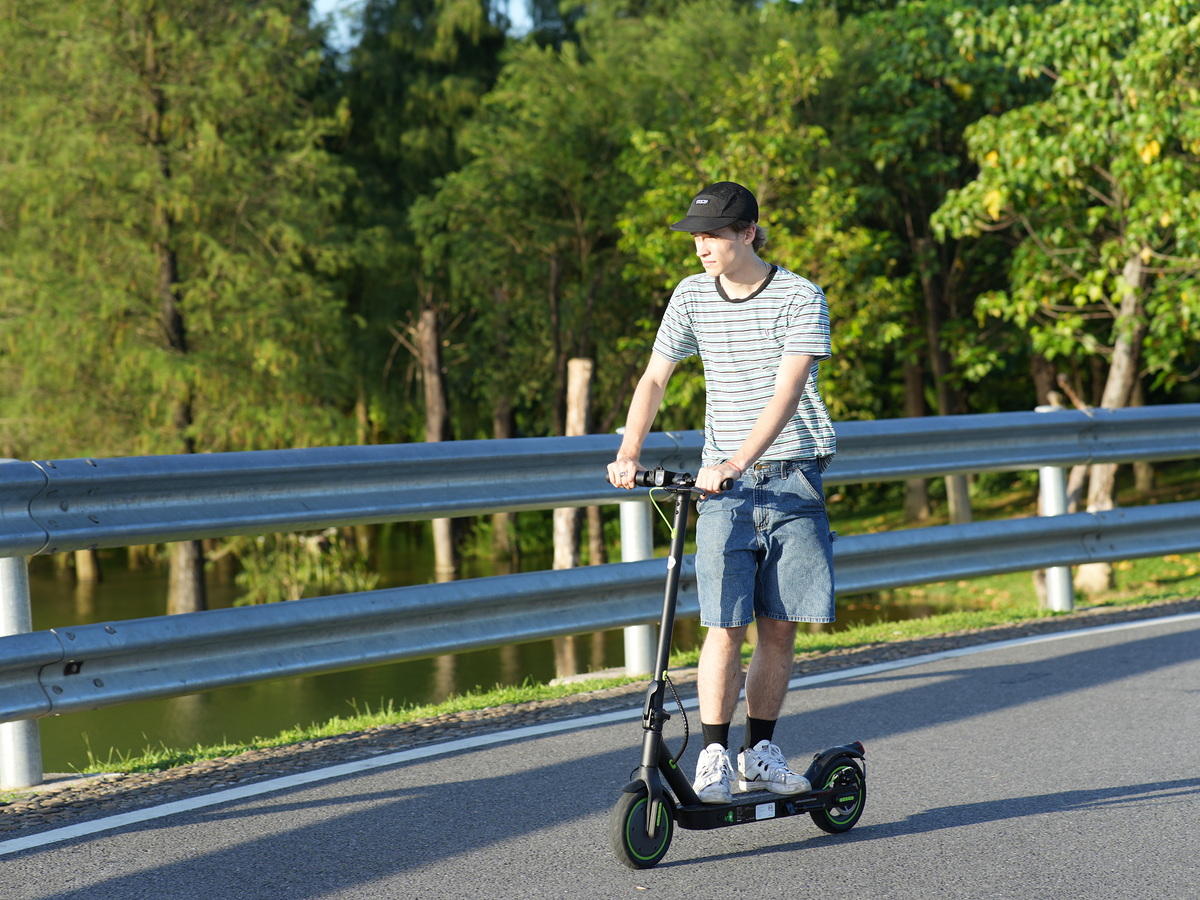 isinwheel S9Pro electric scooter on a road by the trees